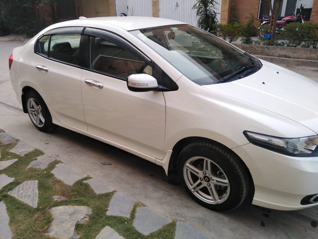 White Honda City car parked on street.