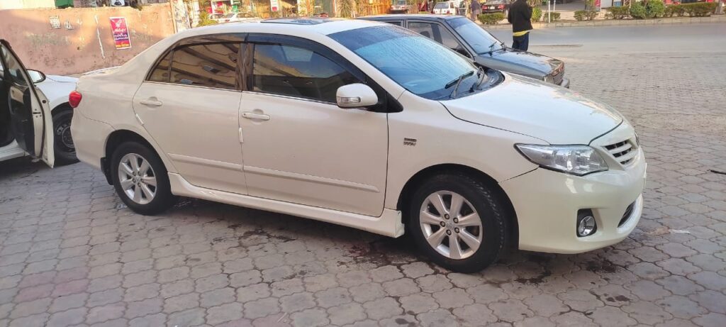 White Toyota Corolla car parked on street.