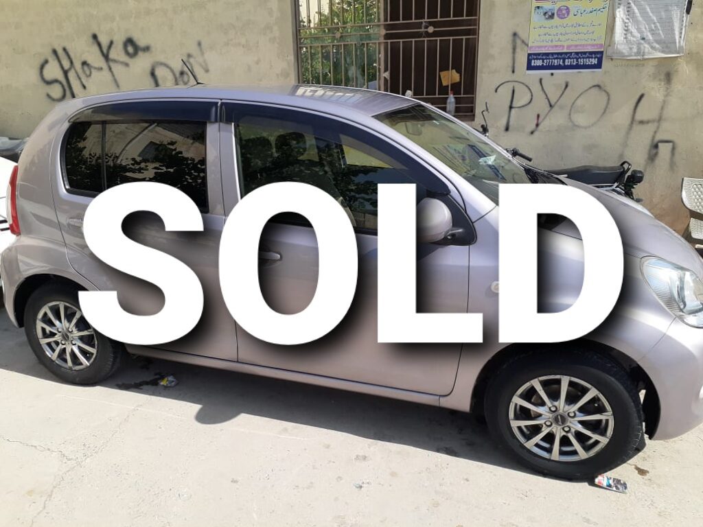 A silver used car with the word SOLD written on it.