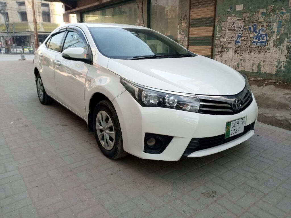 White Toyota Corolla car parked on street.