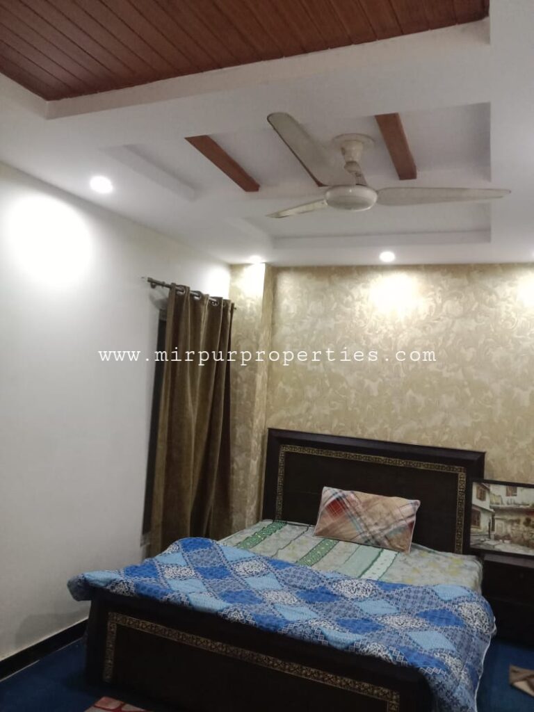 Apartment for rent with a bedroom including a bed and ceiling fan.