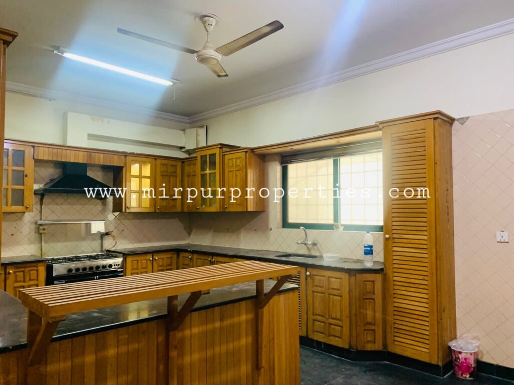 House for rent in Islamabad with wooden cabinets and a ceiling fan.