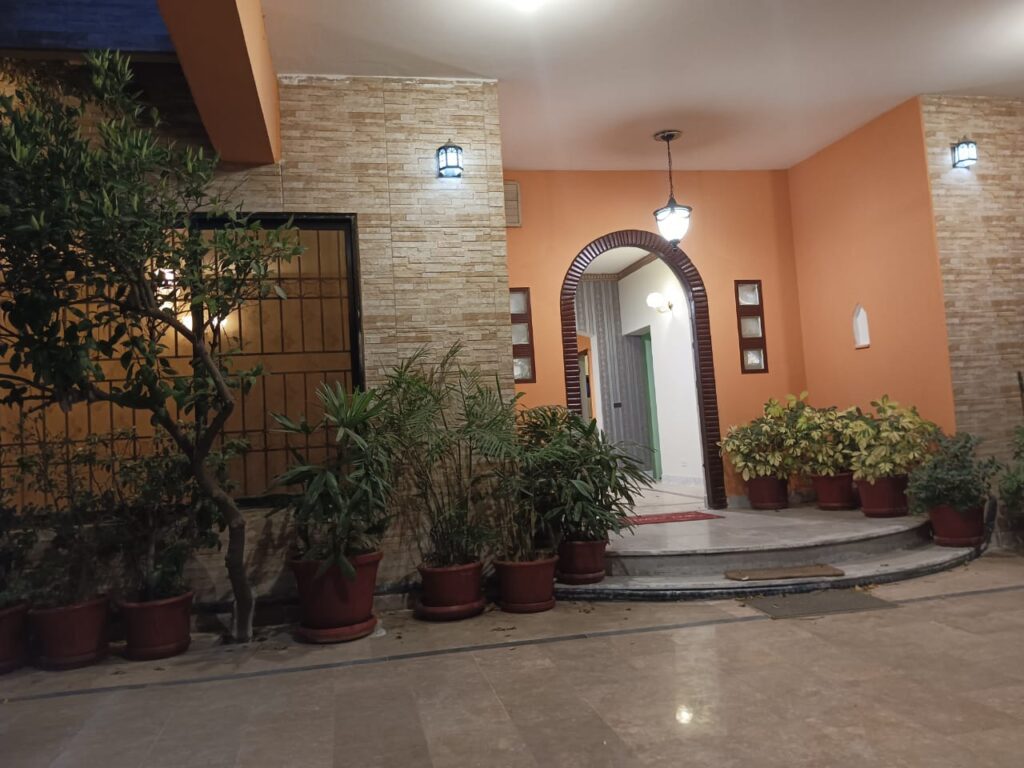 The entrance to a house in Sector A of Islamabad adorned with potted plants.